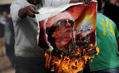 ليبي يحرق صورة للقذافي في بنغازي