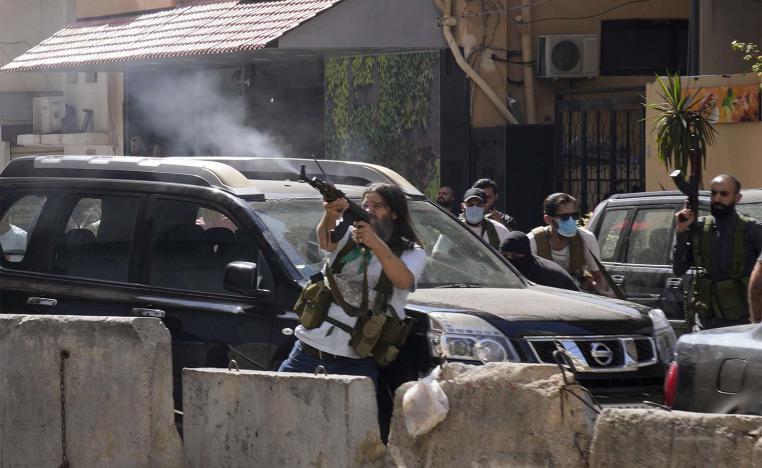 Heavily armed Hezbollah supporters react with to gunfire with gunfire