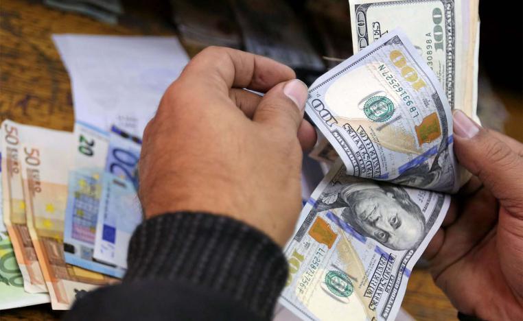 A man counts US dollars and Euros at a money exchange office in central Cairo