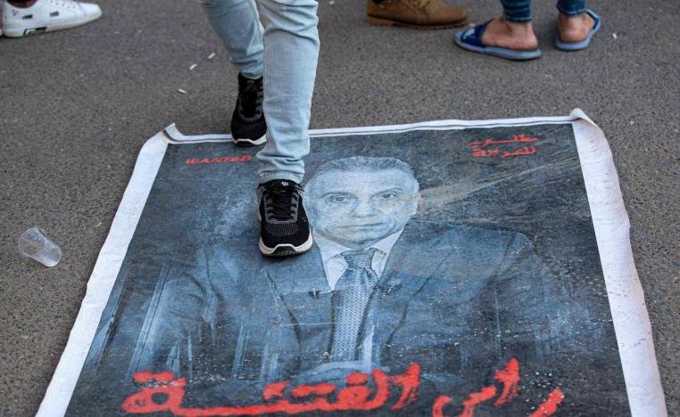 متظاهر من قوات الحشد الشعبي يدوس على صورة مصطفى الكاظمي