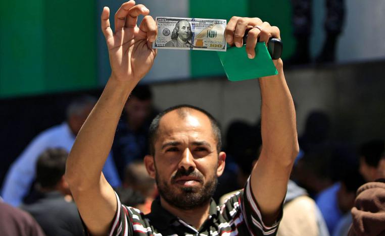فلسطيني في غزة يعرض 100 دولار تلقاها من منحة قطرية
