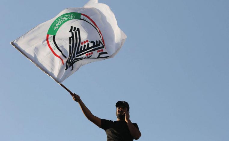 مقاتل من الحشد الشعبي يلوح براية الحشد