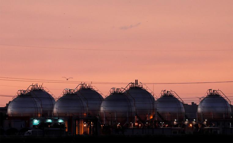 A plant's gas tanks are seen during sunset along a highway of Alexandria