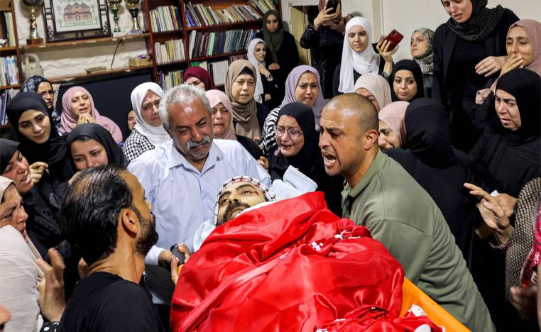 Relatives mourn by the body of Palestinian Ali Harb
