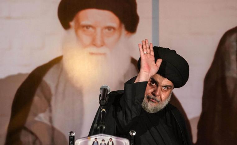 الزعيم الشيعي مقتدى الصدر مع صورة لأبيه محمد صادق الصدر
