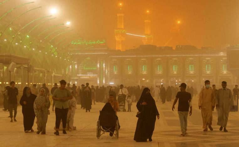 زوار عراقيون لضريح الإمام الحسين في كربلاء أثناء عاصفة ترابية