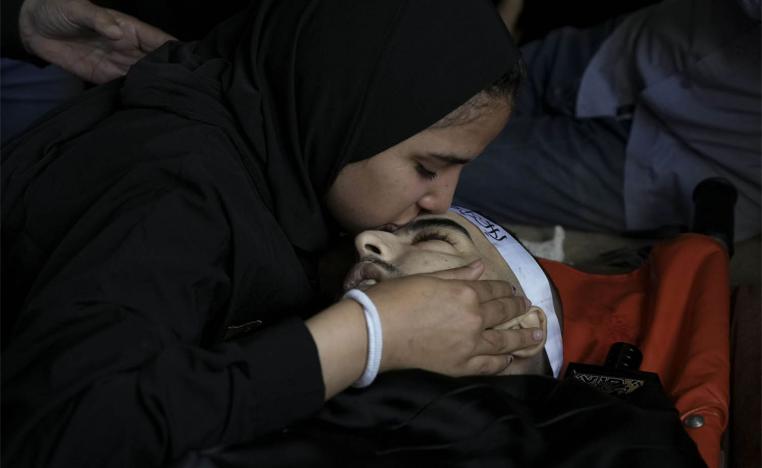 A mourner kisses the body of Palestinian Bara Lahlouh, 24, during his funeral at his family home in Jenin