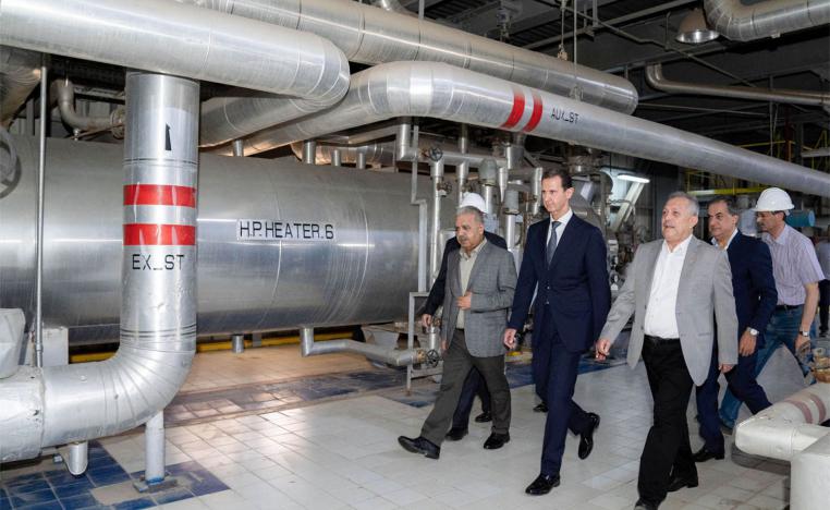 Assad (C) touring a thermal power station in the eastern countryside of Aleppo province