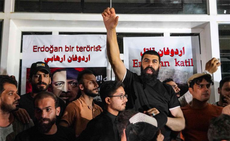 Iraqi protesters shout sloganns in front of the Turkish visa application centre in the central city of Najaf
