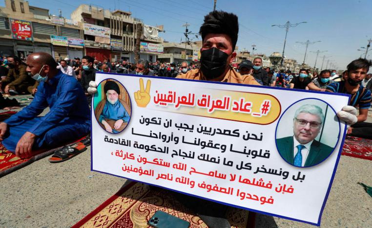 متظاهر عراقي يرفع لافتة مؤيدة لتشكيل الكتلة الصدرية حكومة