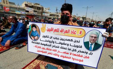 متظاهر عراقي يرفع لافتة مؤيدة لتشكيل الكتلة الصدرية حكومة