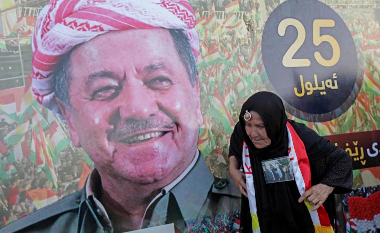 كردية تمر بجانب جدارية للزعيم الكردي مسعود بارزاني