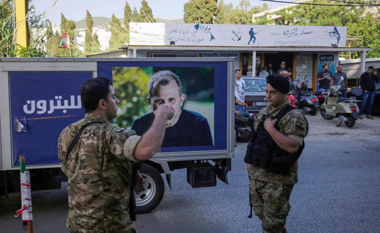 جنود لبنانيون أمام لوحة اعلان أثناء الحملة الانتخابية للتيار الحر