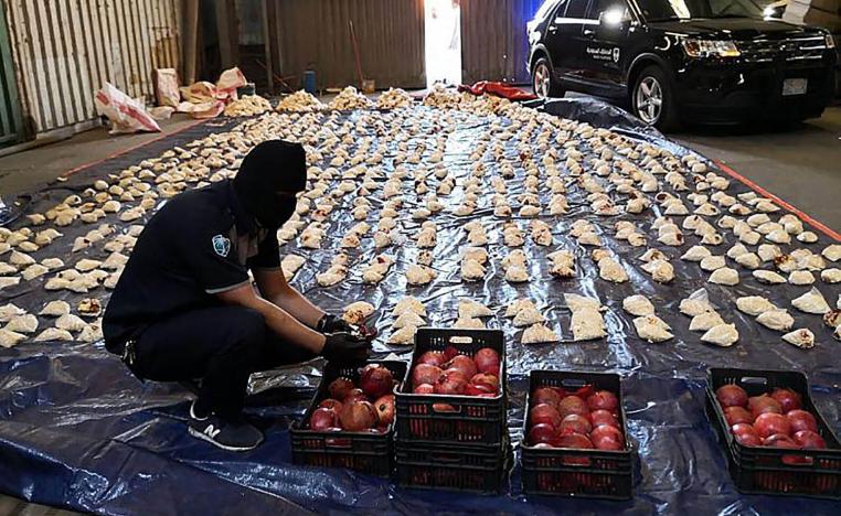 موظف في الجمارك السعودية يستعرض شحنة كبتاغون مهربة
