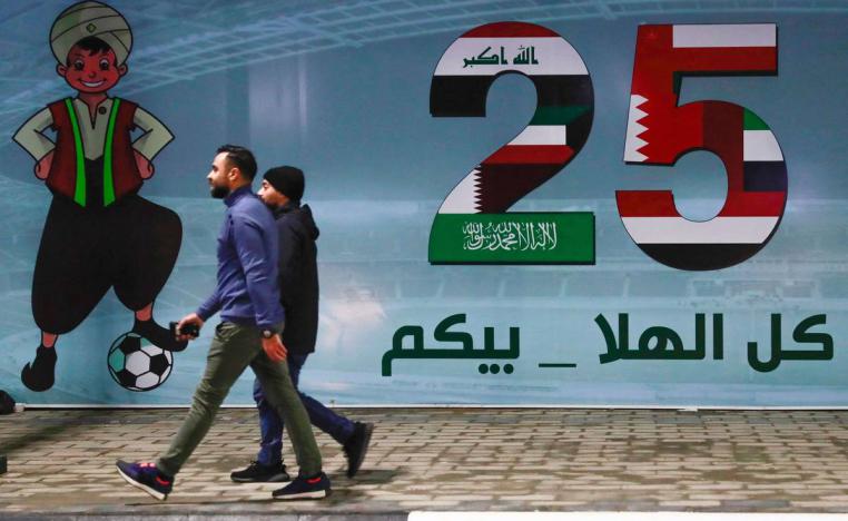 عراقيون يمرون بجانب جدارية تحتفي بخليجي 25