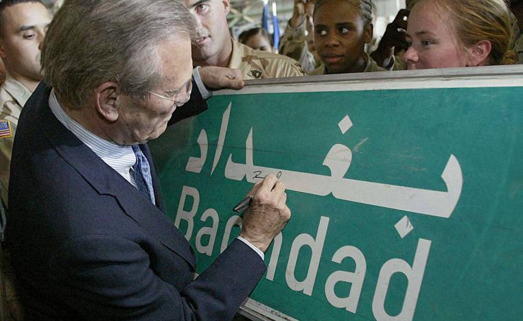 وزير الدفاع الأميركي دونالد رمسفيلد يوقع على لافتة شارع تشير إلى اسم بغداد بعد احتلالها (2003)