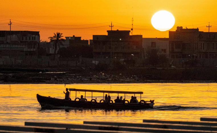 قارب يعبر دجلة وقت الغروب في بغداد