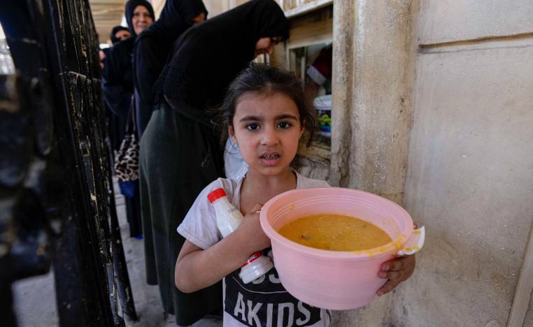 طفلة عراقية تحمل شورية يوزعها مسجد عبدالقادر الكيلاني وسط بغداد