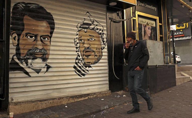 تخطيطات للرئيس الفلسطيني الراحل ياسر عرفات والرئيس العراقي الراحل صدام حسين على واجهة محل في رام الله