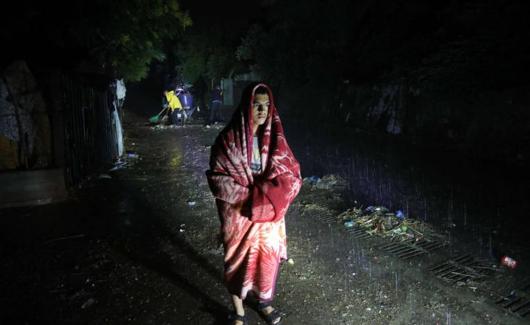 فلسطيني يتلحف بطانية اتقاء من أمطار دانيال في غزة