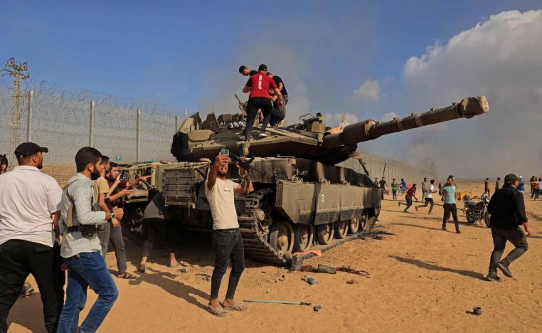 فلسطينيون يأخذون صورا بجانب دبابة إسرائيلية على الحدود مع غزة