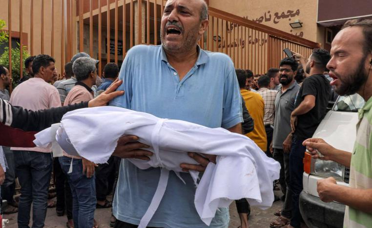 فلسطيني يحمل جثمان طفل قتل في القصف الإسرائيلي لغزة