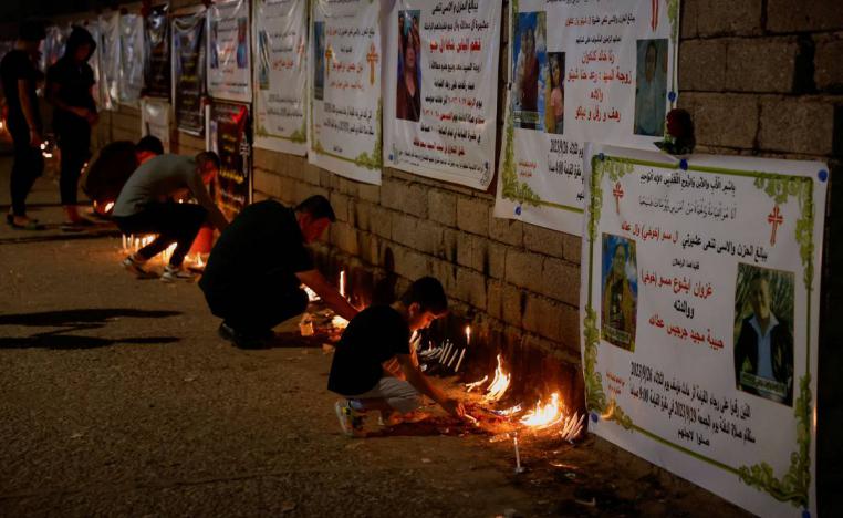 عراقيون مسيحيون يشعلون شموعا تأبينا لضحايا كارثة الحمدانية