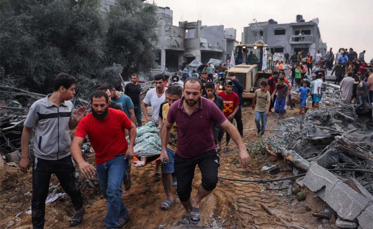 Palestinians transport the body of a victim from the rubble after Israeli strikes in Rafah