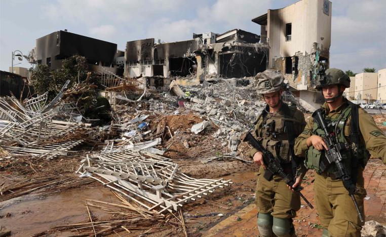 Soldiers walk in front of an Israeli police station that was damaged during battles to dislodge Hamas militants who were stationed inside