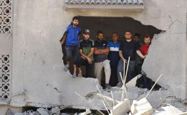 فلسطينيون في مبنى مدمر بالقصف الإسرائيلي على غزة