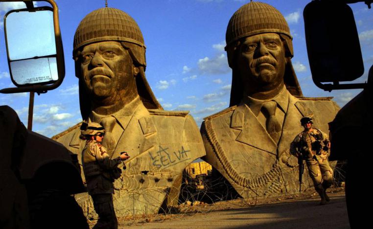 جنود أميركيون مع تماثيل للرئيس العراقي صدام حسين