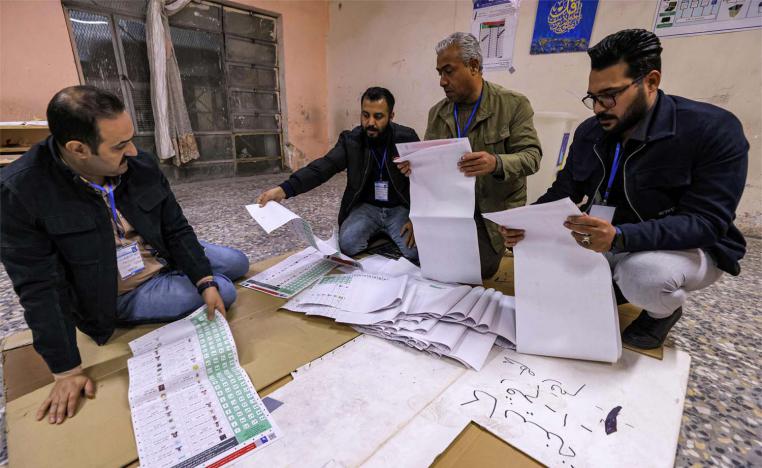 Election Commission employees count ballots at a polling station in Sadr City in eastern Baghdad 