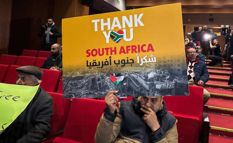 ناشط يرفع لافتة تأييد لإنجاز جنوب أفريقيا بإدانة إسرائيل في محكمة العدل الدولية
