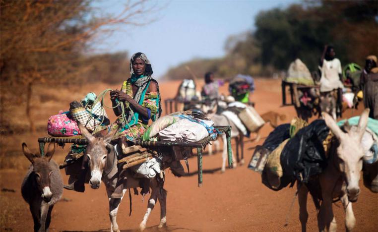 A woman rides a donkey as nomad families from the Misseryia area in Abyei region