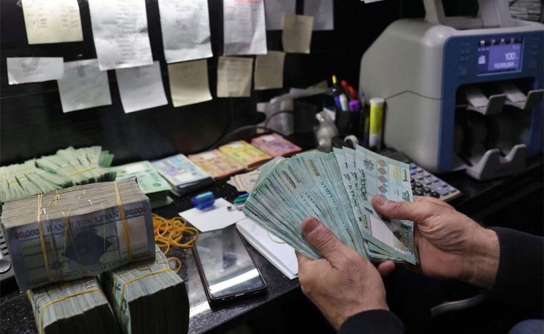 A man handles Lebanese pound bills at a currency exchange office in Beirut