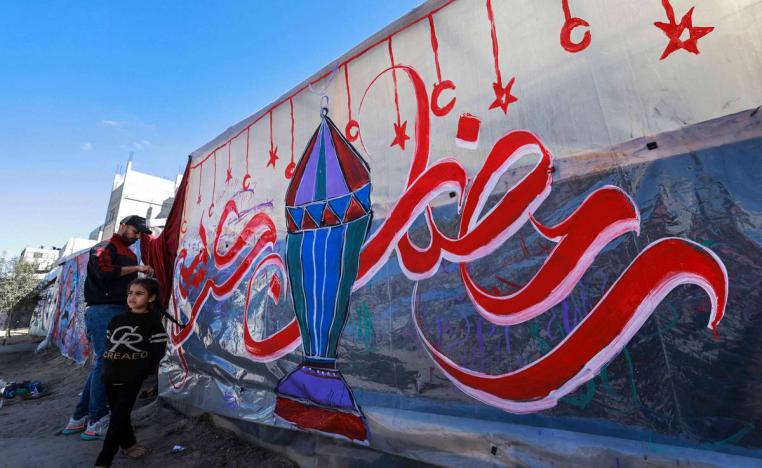 فلسطيني يخط على جدار احتفالا برمضان