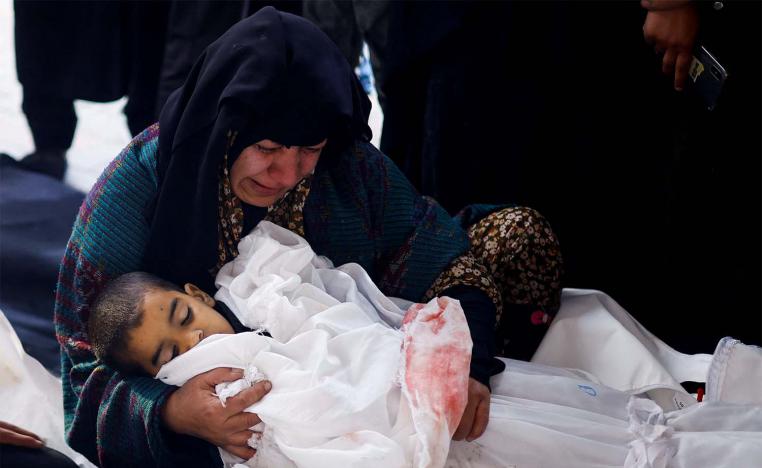  A Palestinian woman holds the body of a Palestinian child killed in Israeli strikes on Rafah