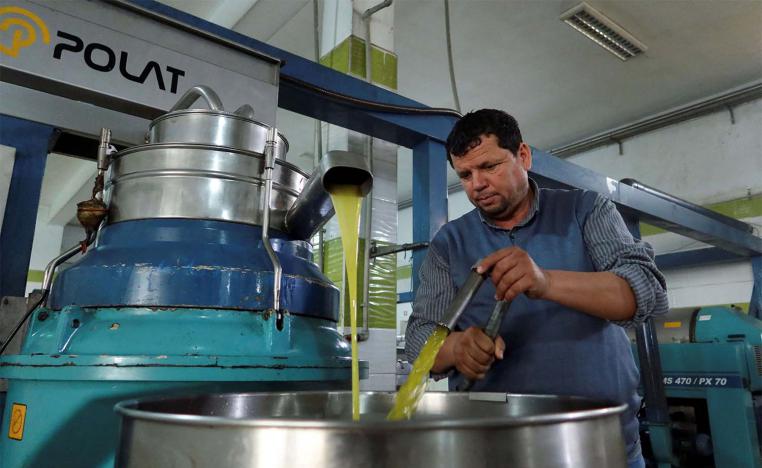 Tunisian olive oil producer, Mustapha Mtiraoui, works inside his oil mill in Kairouan