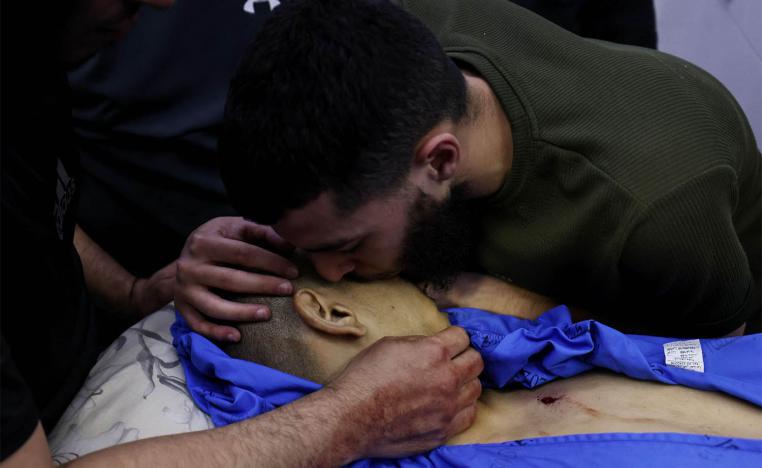 A Palestinian man bids farewell to a relative killed in an Israeli army raid on Jenin at the mortuary 