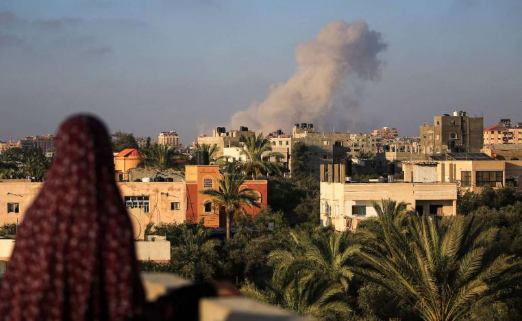 فلسطينية تنظر إلى قصف إسرائيلي وسط قطاع غزة