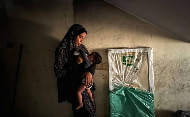 فلسطينية مع طفلها الذي يعاني من نقص التغذية