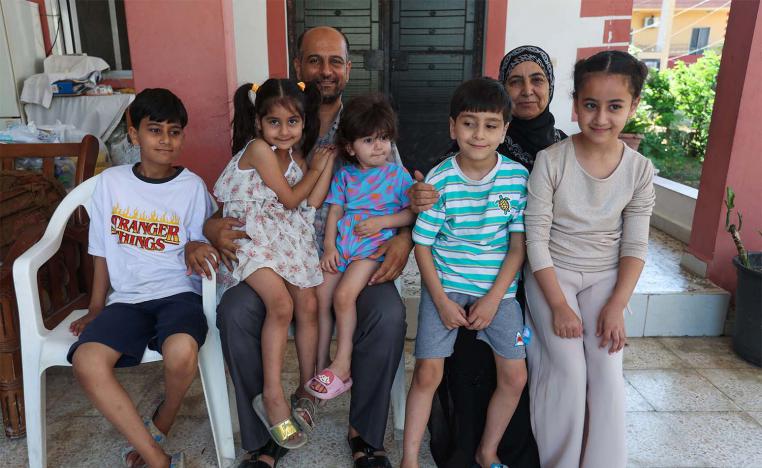 Samer Abu Della, displaced Lebanese from southern border village of Yarine, poses for a picture with his family