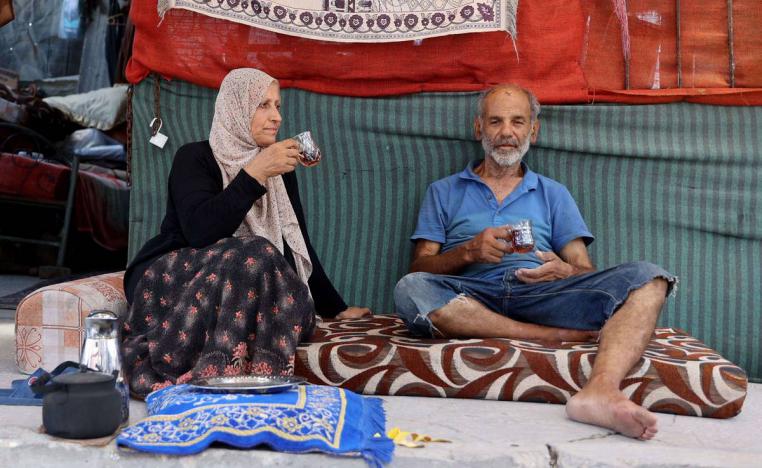 عائلة فلسطينية بالقرب من انقاض بيتها المهدم في غزة