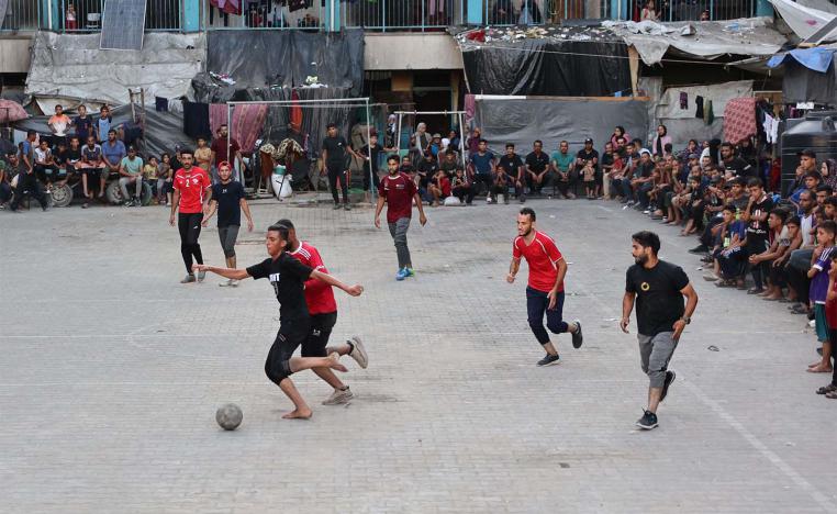 Playing football in the courtyard of a school-turned-shelter