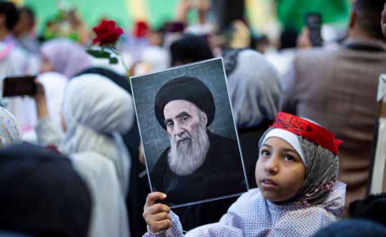 طفلة عراقية ترفع صورة آية الله علي السيستاني