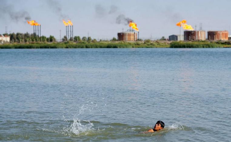 طفل عراقي يسبح بالقرب من منشآت نفطية في حقول نهر بن عمر بالبصرة