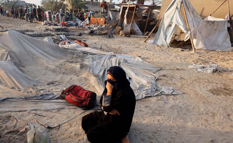 A Palestinian woman cries at the site following Israeli strikes on the tent camp sheltering displaced people
