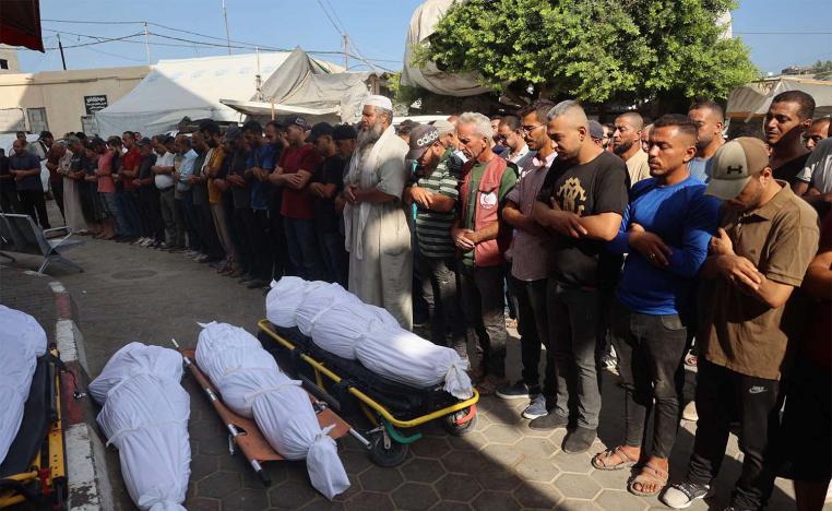 Palestinians mourn over the bodies of victims of Israeli bombardment in Deir el-Balah