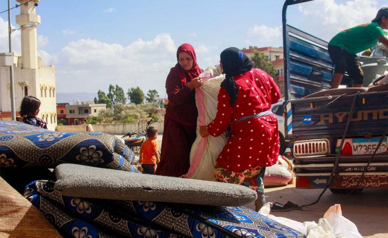 Syrian refugees load their belongings on a truck as they prepare to leave the southern Lebanese village of Wazzani