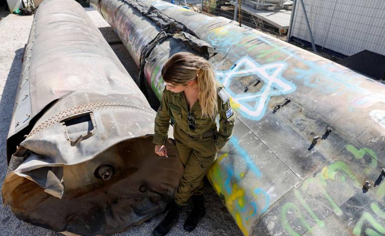جندية إسرائيلية بجانب صاروخ إيراني تم اسقاطه
